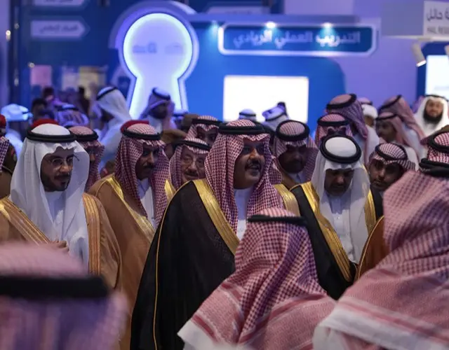 Guests in bishts and shemaghs walking through a Kafeela event hall